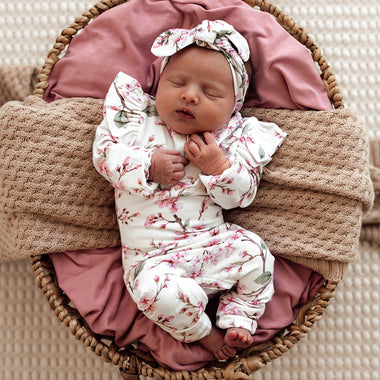 Baby wearing Cherry Blossom Organic Growsuit
